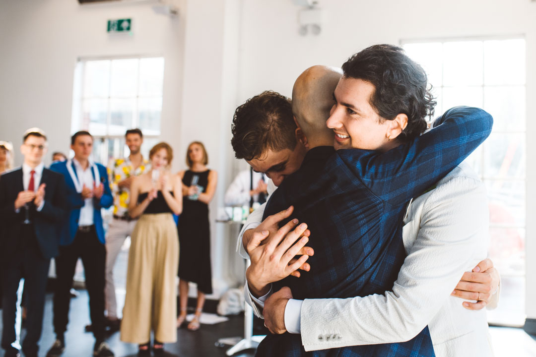 grooms and best man hugging