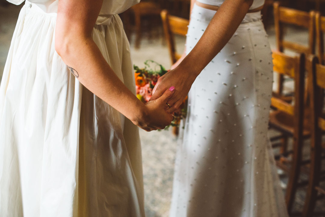 brides holding hands Asylum Chapel lesbian wedding