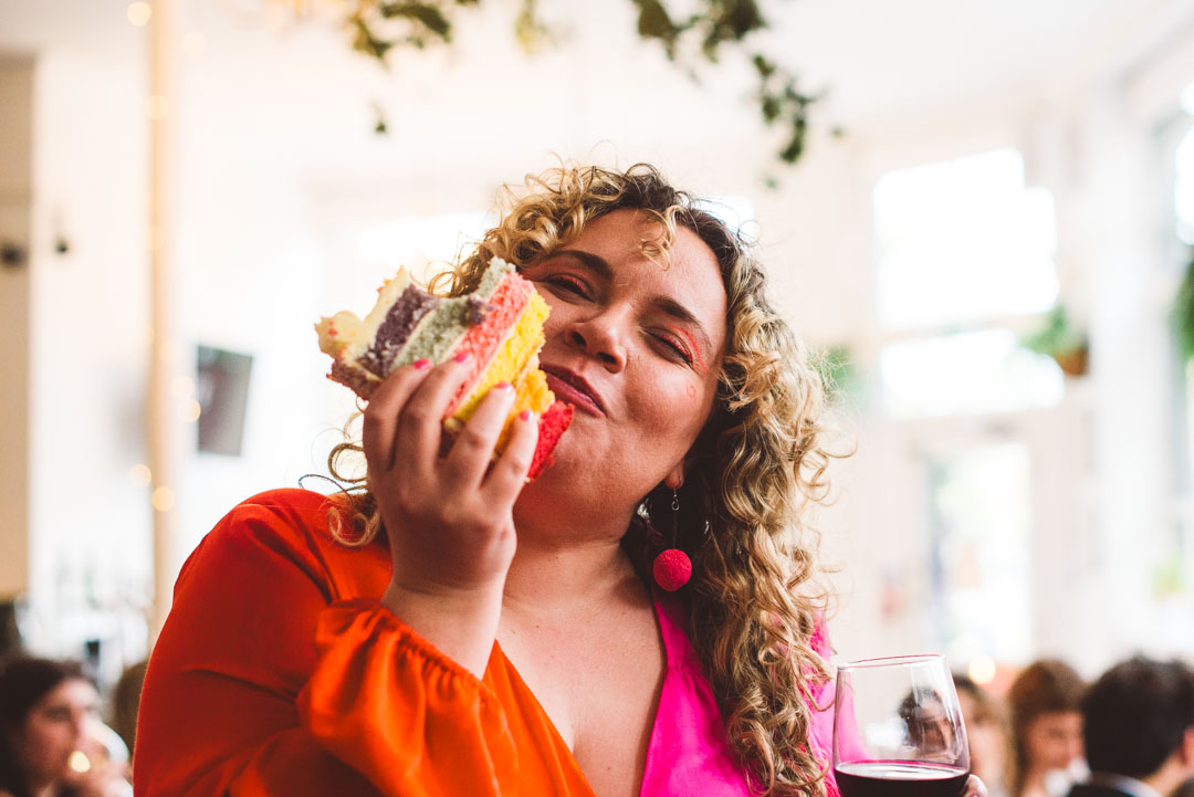 guest eating rainbow wedding cake