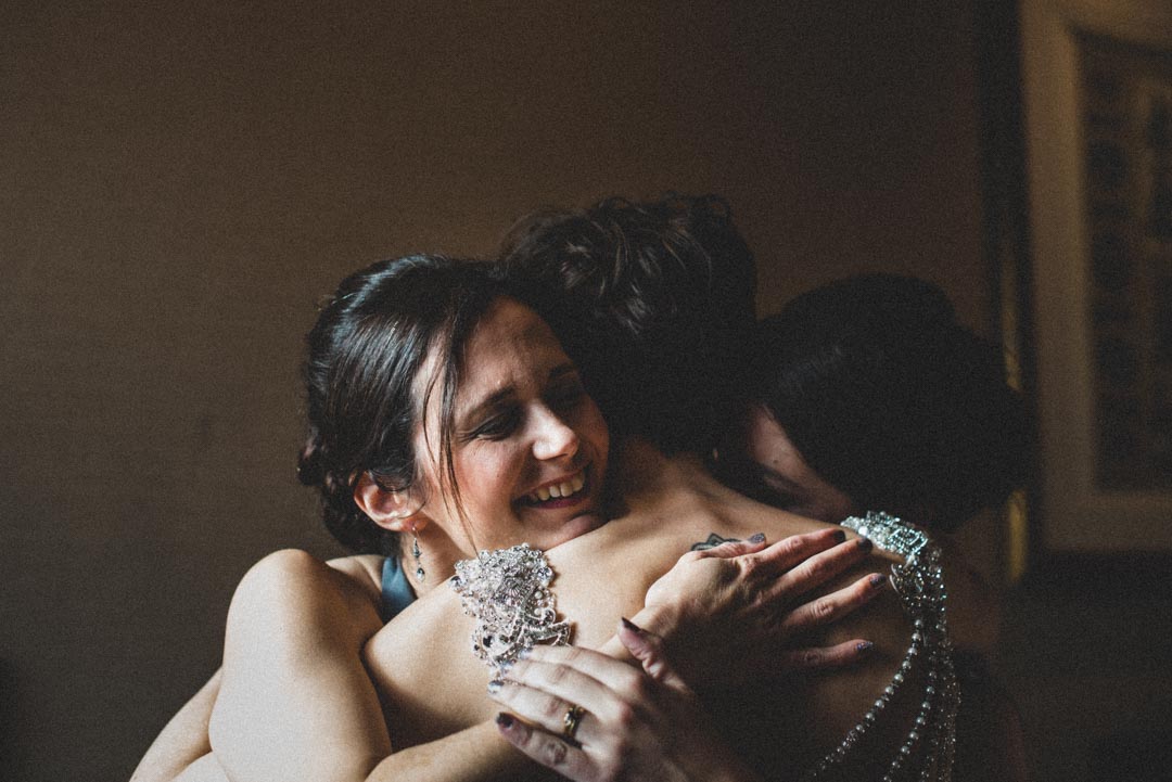 bridesmaids hugging bride
