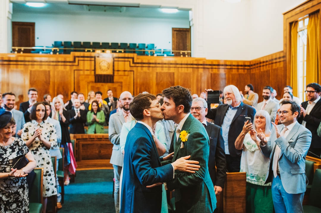 council chamber same-sex wedding couple kissing
