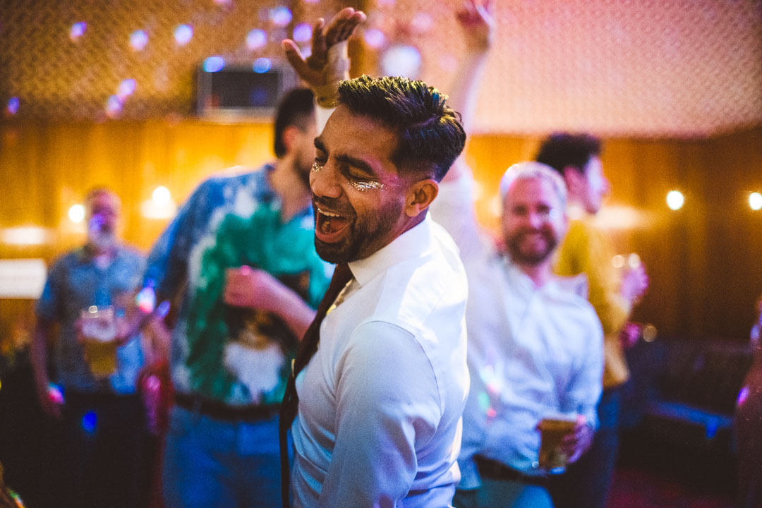 gay wedding photography guest dancing and signing