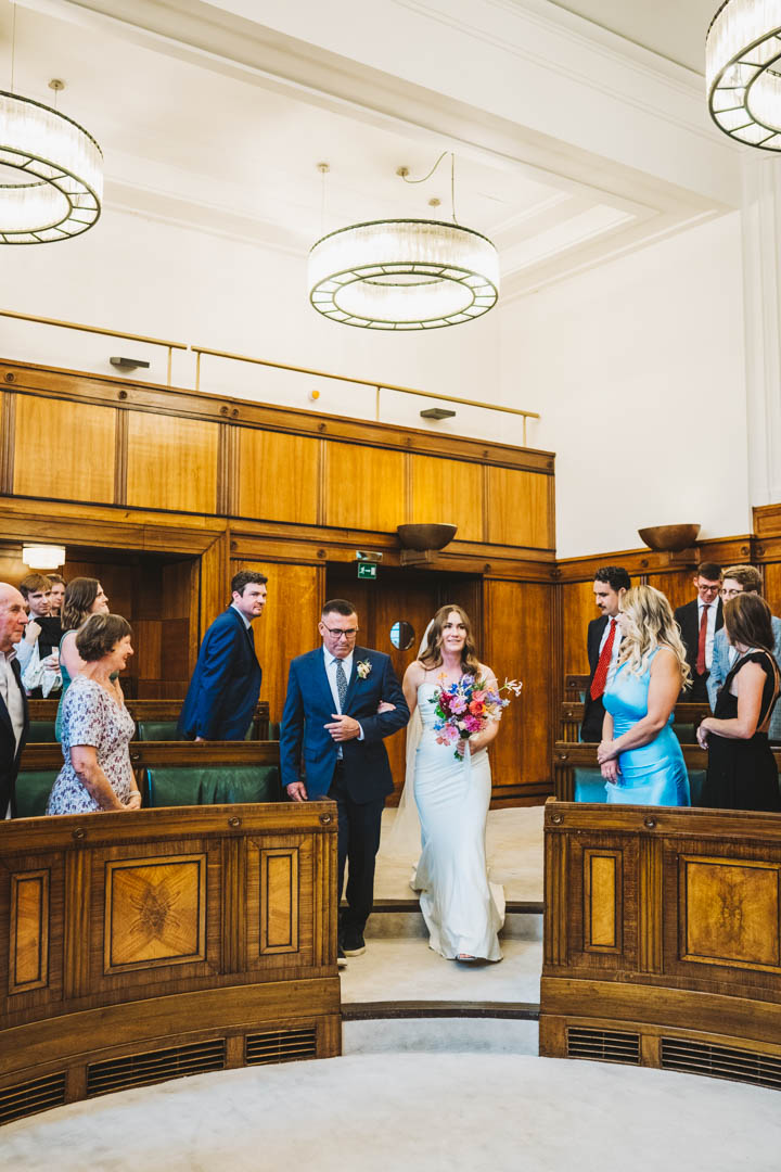 bride and dad walking in Council Chamber