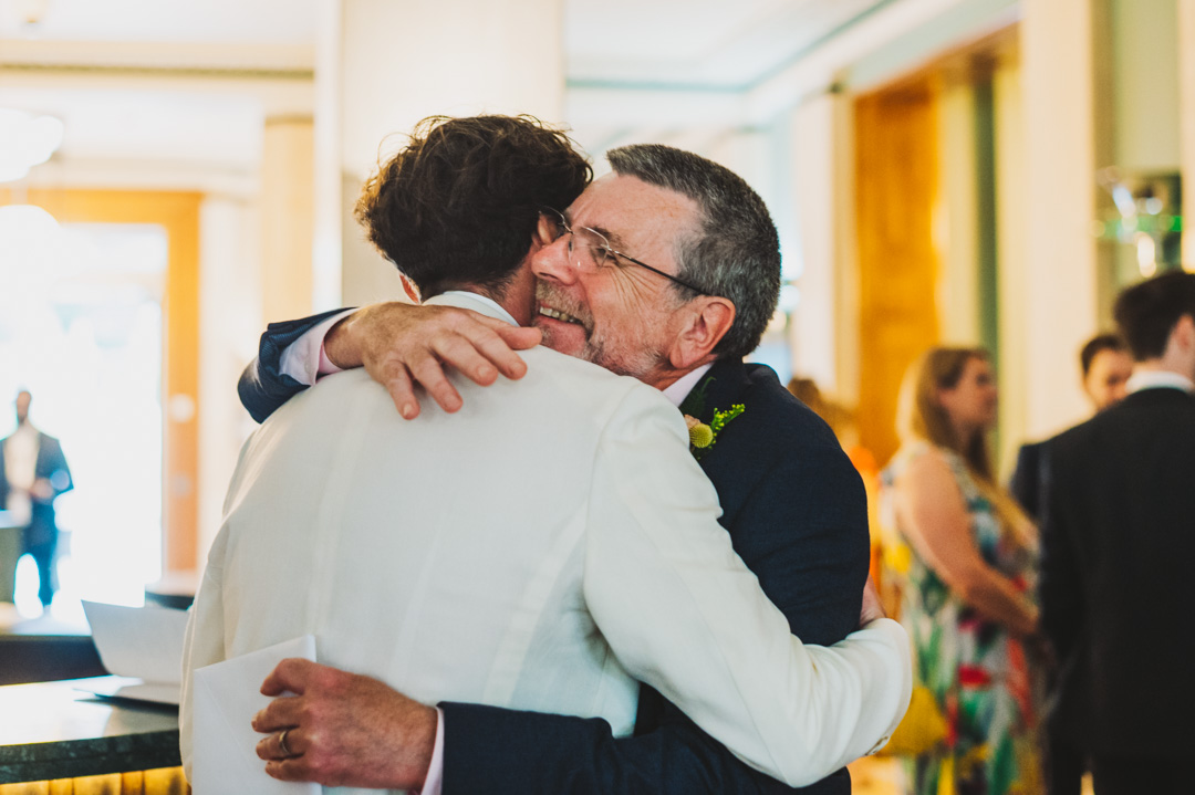 father hugs groom